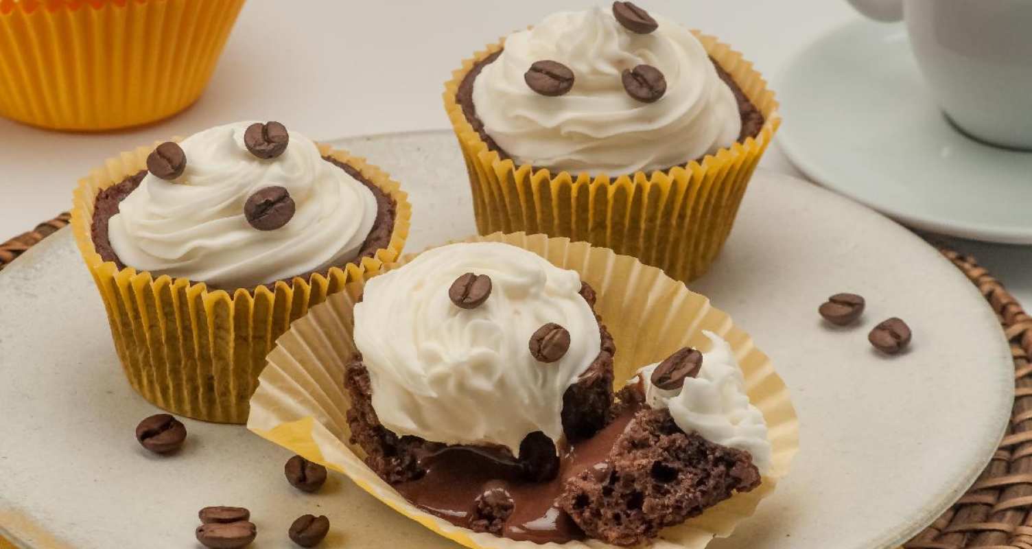 imagem de fundo de 3 cupcakes com chantilly e grãos de café